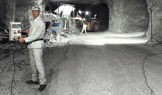 un uomo in abito bianco si trova in una miniera di sale e tiene in mano una combinazione di recipienti AMAXX