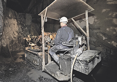 Un operaio siede in un escavatore nel pozzo minerario
