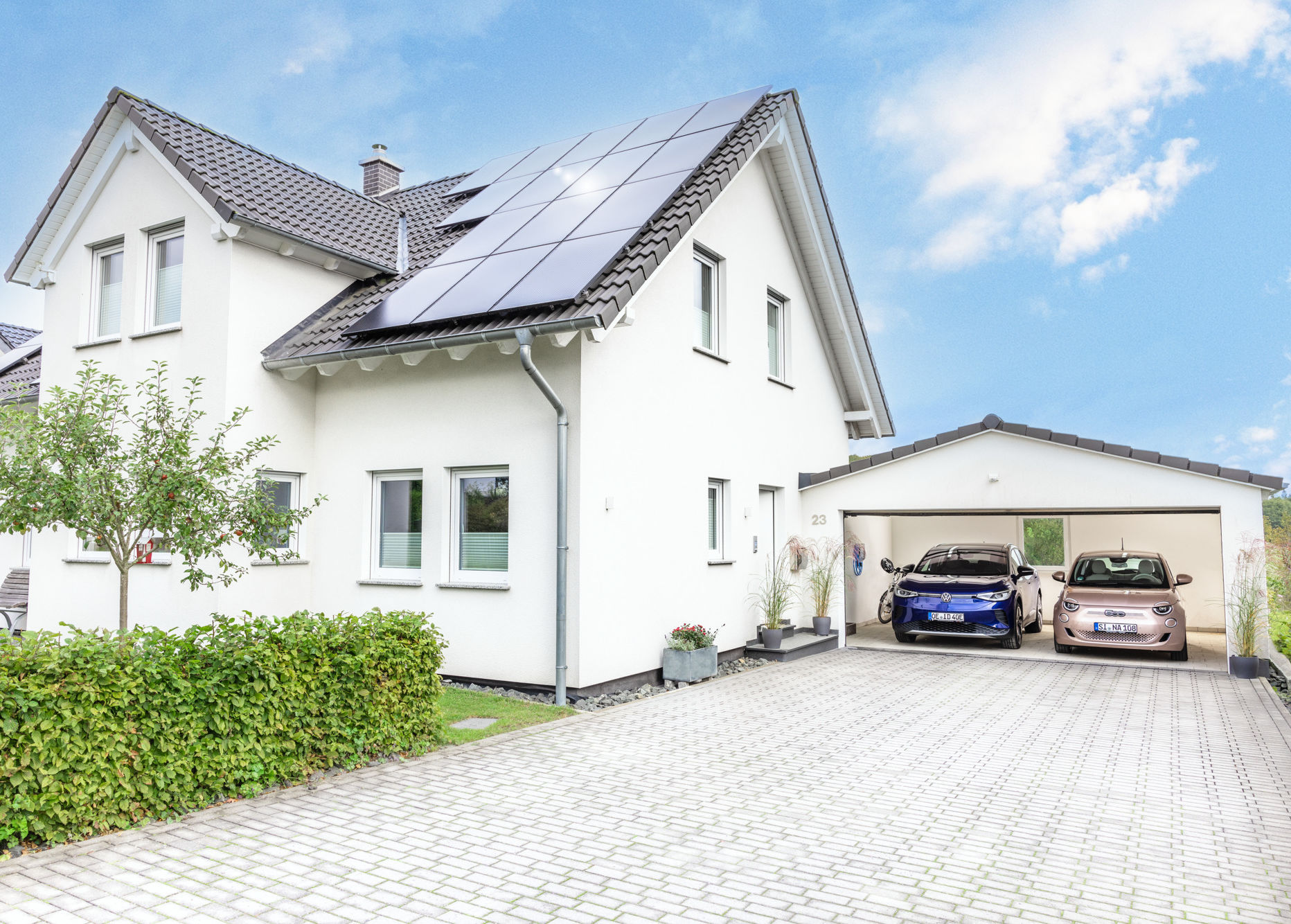 Haus mit PV-Anlage auf dem Dach und Wallbox in der Garage